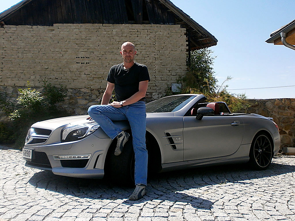 Petr Jansa sedí na kapotě stříbrného Mercedesu SL