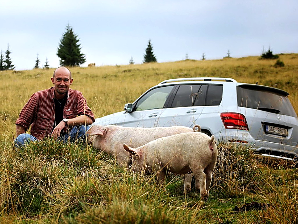 Petr Jansa s ovcí u stříbrného SUV Mercedes GL