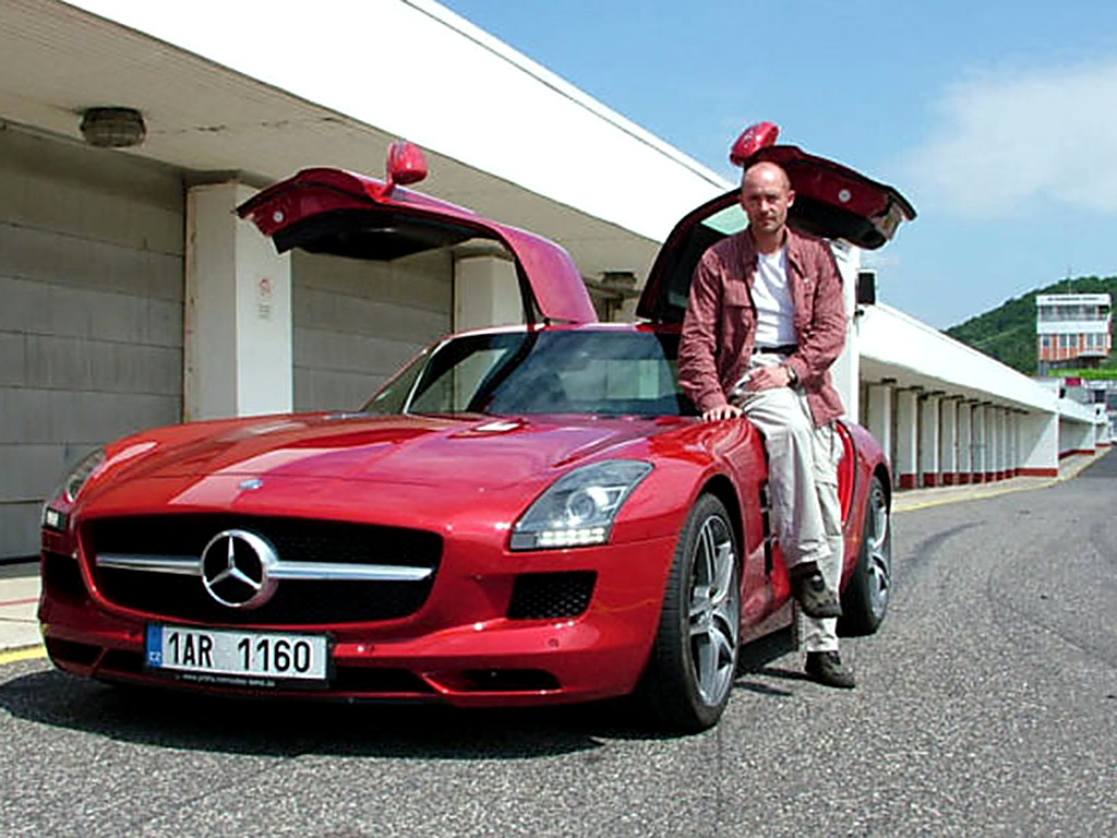 Petr Jansa u červeného Mercedesu SLS AMG s křídlovými dveřmi