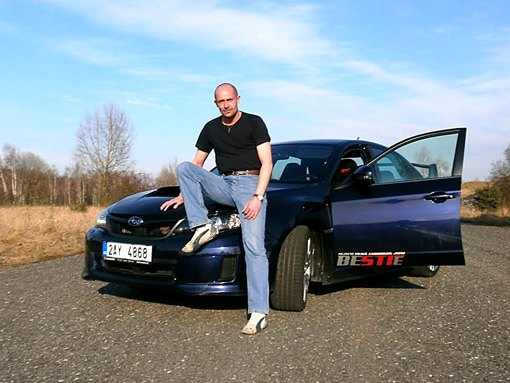 Petr Jansa sedí na kapotě černého Dodge Viper